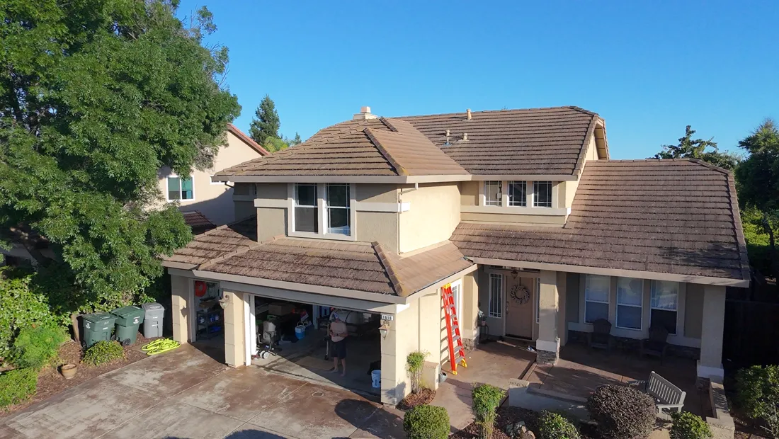 Two-story Rocklin area home with a concrete tile roof and a ladder staged at the garage